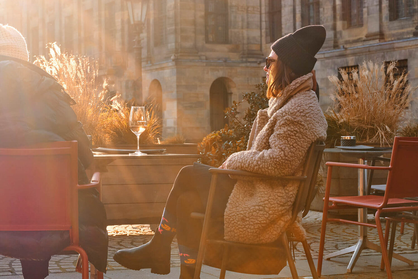 Gast op een verwarmde stoel van Sit & Heat op een zonnig winterterras